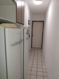 uma cozinha com um frigorífico e um corredor com uma porta em Flat no hotel fazenda portal de Gravatá em Gravatá