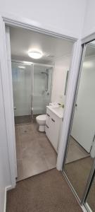 a bathroom with a shower and a toilet and a sink at Chasely Apartment Hotel in Brisbane