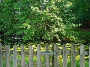 een houten hek voor een vijver bij 6 person holiday home in MARIESTAD in Mariestad