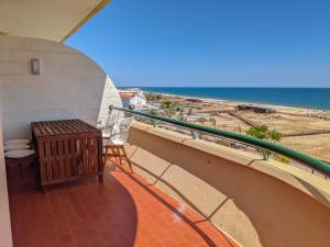 Un balcón con mesa y vista a la playa. en Seasun Vacation Rentals - OCEAN, en Monte Gordo