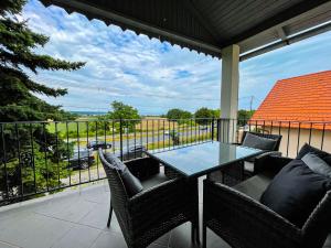 patio ze stołem i krzesłami na balkonie w obiekcie Pine&Chill Apartments w mieście Balatonalmádi