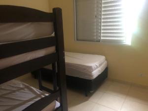 a bedroom with two bunk beds and a window at Linda Casa pé na areia em Mongagua in Mongaguá