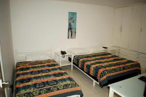 1 dormitorio con 2 camas, mesa y una foto en la pared en APARTAMENTO EN EL LAGUITO, CARTAGENA, en Cartagena de Indias