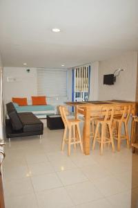 a living room with a couch and a table and chairs at APARTAMENTO EN EL LAGUITO, CARTAGENA in Cartagena de Indias
