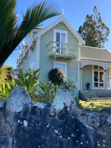 une maison avec des rochers devant elle dans l'établissement Taiparoro House, à Tauranga