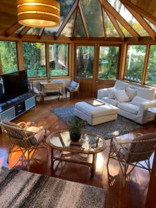 a living room with a white couch and chairs at Taiparoro House in Tauranga