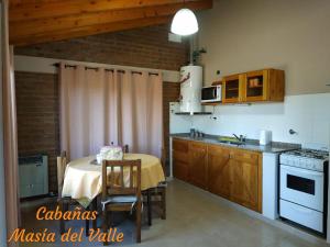 a kitchen with a table and a kitchen with a stove at Masia del Valle in Trevelín
