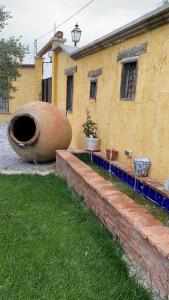 ein gelbes Gebäude mit einem großen Rohr neben einem Hof in der Unterkunft Cortijo Bustamante in Baza