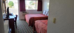 Habitación de hotel con 2 camas y ventana en Stagecoach Motel, en La Junta