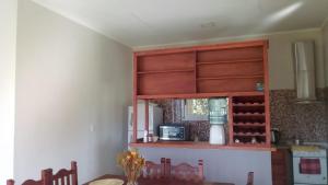 een keuken met een tafel en een kast met wijnflessen bij Casimiro Casa de Campo - Guest's house in Colonia Carlos Pellegrini