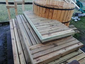 une terrasse en bois avec un tonneau à côté dans l'établissement Cabañas Los Canelos Pucon, Hermosa Granja de 20 hectaréas a orillas del Río Liucura, à Pucón