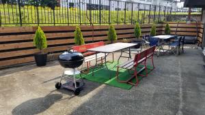 - un barbecue, des tables et des chaises sur la terrasse dans l'établissement Hakuba Downtown Apartments, à Hakuba