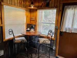 Whitetail Creek Camping Resort في Lead: مطبخ صغير مع طاولة وكراسي في كابينة