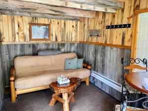 uma sala de estar com um sofá e uma mesa em Whitetail Creek Camping Resort em Lead