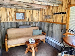 Whitetail Creek Camping Resort في Lead: غرفة معيشة مع أريكة وطاولة