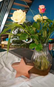 Un jarrón con flores y una estrella en una mesa en LA MAISON BLEUE, à 20 mn de Strasbourg, sur la route des vins, jusqu'à 6 personnes, Sélestat en Sélestat