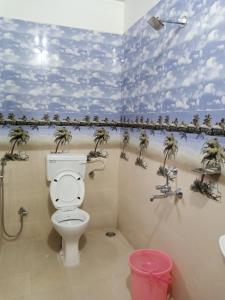 baño con aseo y palmeras en la pared en ROYAL STONE VILLA, en Mahabaleshwar 19 fotos más