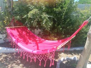 a red hammock sitting in a yard at H2A in Aroeira