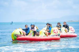 a group of children riding on two inflatable tubes in the water at Hotel Monterey Okinawa Spa & Resort in Onna