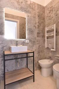een badkamer met een wastafel, een toilet en een spiegel bij Casa Salemi - Western Sicily Home in Salemi