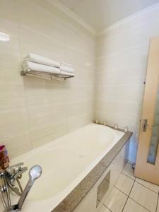 a bathroom with a bath tub and towels at Phoenix Rising Apartment in Midrand