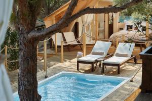 a swimming pool with two chairs and a tree at Abeille Maison Glamping Resort Zlatni Rat -Adults Only in Bol