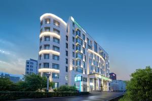 a tall white building with lights on it at Holiday Inn Express - Harbin Songbei New District, an IHG Hotel in Harbin