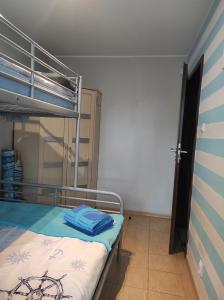 a bedroom with a bunk bed with blue towels on it at Leukozja in Krynica Morska