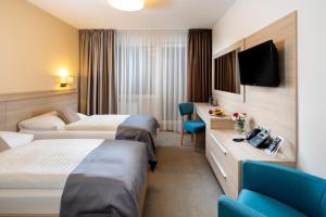 um quarto de hotel com duas camas e uma televisão em Hotel Park em Dolný Kubín