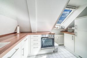 kuchnia z białymi szafkami i świetlikiem w obiekcie Mitten im Herzen von Hannover / Familienfreundlich / 80m² w Hanowerze