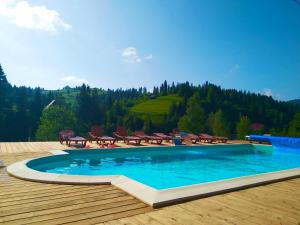 - une piscine sur une terrasse en bois avec des tables et des chaises dans l'établissement Plavianska Sadyba, à Plavie