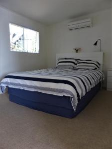 a bedroom with a large bed in a white room at Riverfront Holiday House in Wellington East