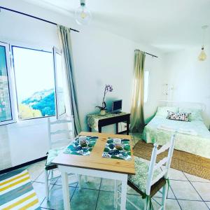 een kamer met een tafel en een bed en een slaapkamer bij “Da Senso” Relax nel verde vista mare in Finale Ligure