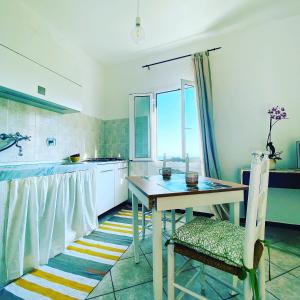 een keuken met een tafel en een raam erin bij “Da Senso” Relax nel verde vista mare in Finale Ligure