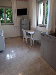a kitchen with a table and chairs in a room at Villa Ca'Bianca in Bibione