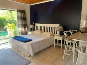 a room with a table, chairs, and a window at The Little Hideaway Guesthouse in Stellenbosch