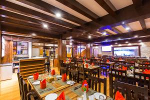 a restaurant with tables and chairs in a room at Hotel Kausi in Pokhara
