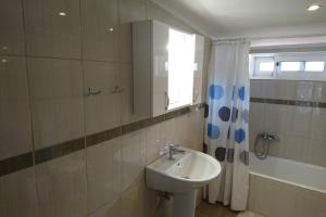 a bathroom with a sink and a mirror and a shower at KORONI MARE -Sea view apartment/διαμέρισμα με θέα στην θάλασσα in Koroni