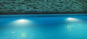 a swimming pool with two lights next to a brick wall at VILLA METATRON U DOMA in Balchik