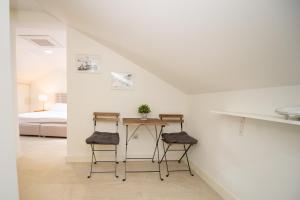a white room with a table and two stools at Katareo Apartments in Kotor