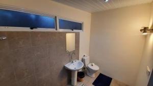 y baño con lavabo y aseo. en Matira house en Bora Bora