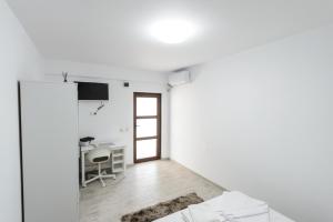 ein weißes Zimmer mit einem Tisch und einem Stuhl in der Unterkunft Toma Residence in Eforie Nord