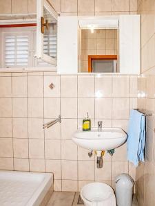ein Bad mit einem Waschbecken und einem WC in der Unterkunft Apartmani Miljak Trpanj in Trpanj
