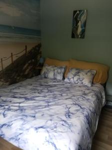 a bed with a blue and white comforter in a bedroom at Chez Fanny Chambres d'hôtes in Fos-sur-Mer