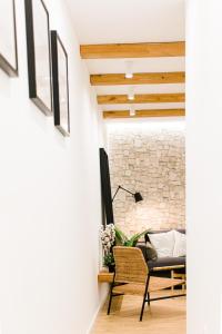 ein Wohnzimmer mit einer Steinmauer und einem Stuhl in der Unterkunft Estupendo Piso de 2 dormitorios en la Gran Vía. A/A. Wifi. in Salamanca
