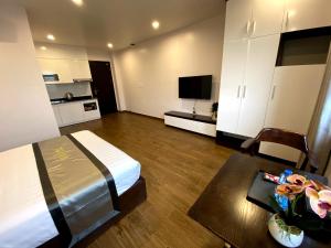 a bedroom with a bed and a table and a television at The Nova Hotel & Apartment in Hai Phong
