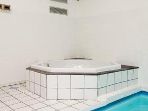 y baño con bañera y suelo de baldosa. en 14 person holiday home in Vejers Strand, en Vejers Strand