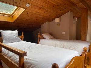 two beds in a room with a attic at SISCARO - Peu del Riu 310 - Vall d'Incles - Soldeu in Incles