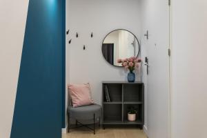um quarto com uma cadeira e um espelho em Barska 69 Apartments na Cracóvia