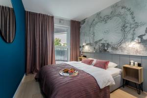 a bedroom with a bed with a tray of fruit on it at Barska 69 Apartments in Kraków